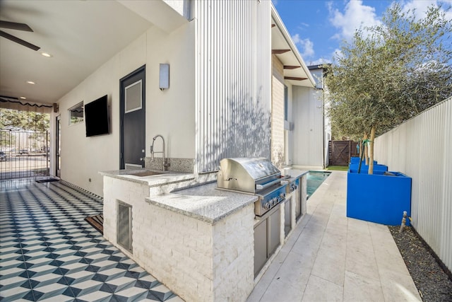 view of patio with exterior kitchen, area for grilling, sink, and ceiling fan