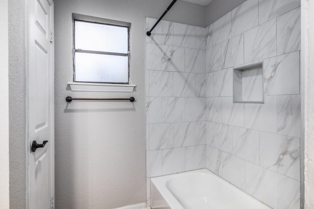 bathroom featuring tiled shower / bath