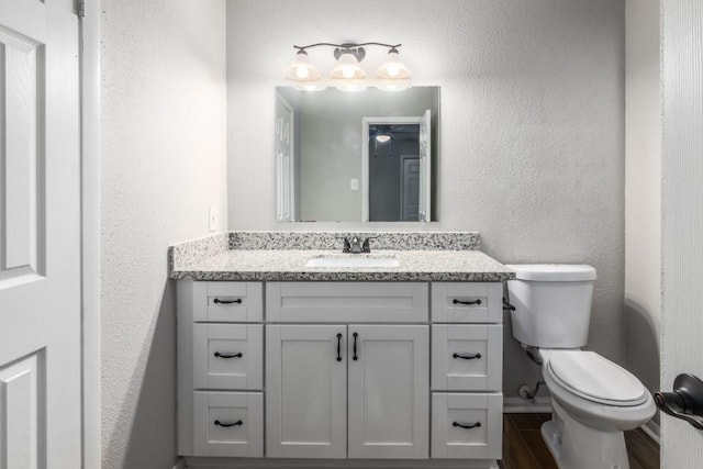 bathroom with vanity, hardwood / wood-style floors, and toilet