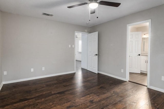 unfurnished bedroom with ensuite bathroom, dark hardwood / wood-style floors, and ceiling fan