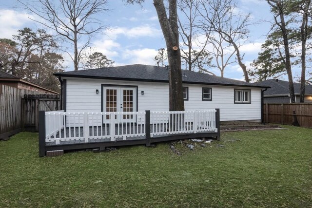 rear view of house with french doors, a yard, and a deck