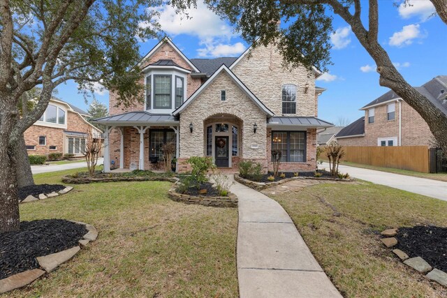 view of front of home featuring covered porch and a front yard