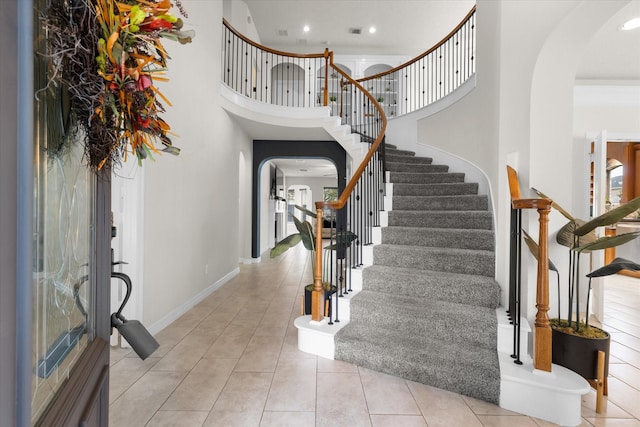 foyer entrance with light tile patterned floors and a high ceiling