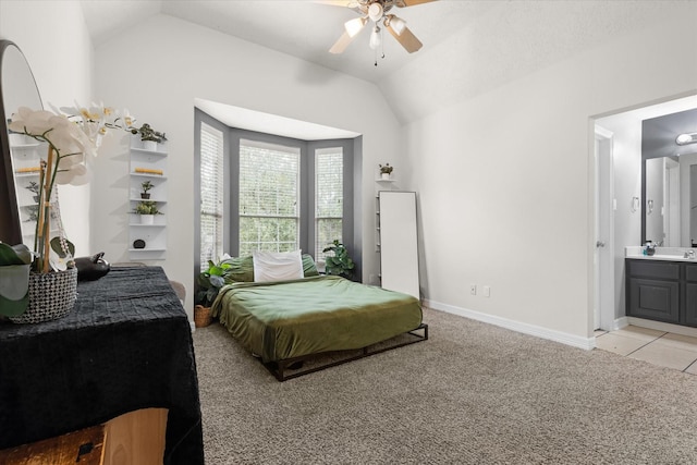 bedroom featuring vaulted ceiling, light carpet, ceiling fan, and ensuite bathroom