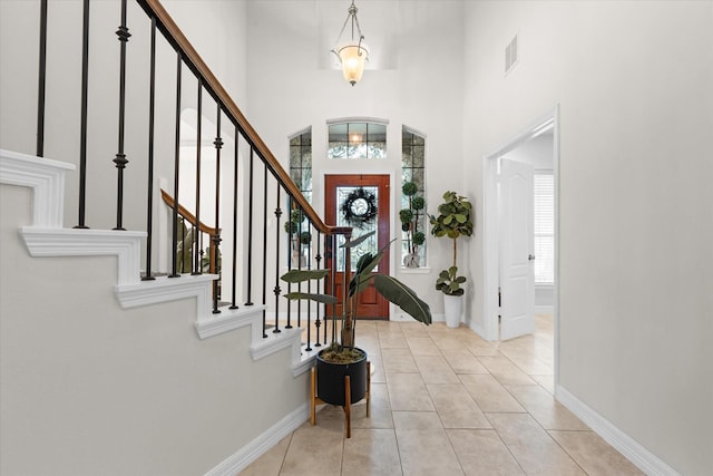 tiled foyer featuring a wealth of natural light and a high ceiling