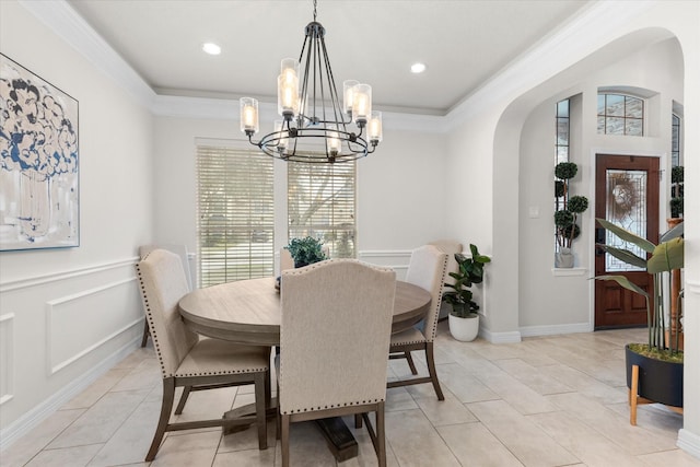 tiled dining space featuring an inviting chandelier, ornamental molding, and a wealth of natural light