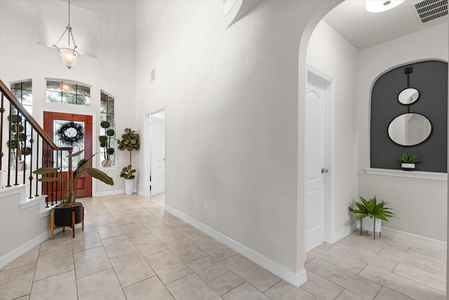 tiled foyer entrance with a towering ceiling