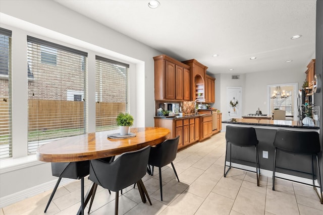 kitchen featuring an inviting chandelier, sink, tasteful backsplash, and light tile patterned flooring