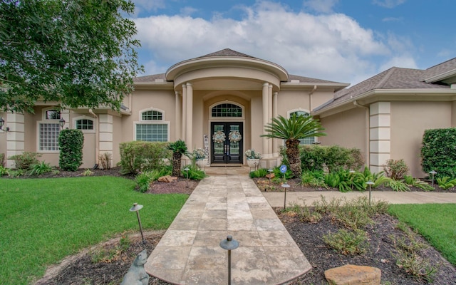 property entrance with a yard and french doors