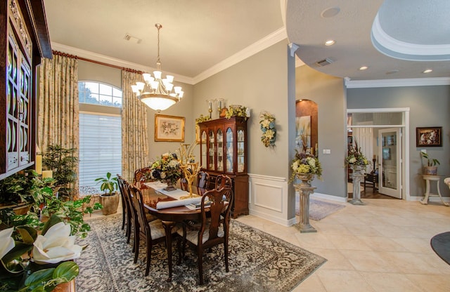 dining space with an inviting chandelier, ornamental molding, a textured ceiling, and light tile patterned floors