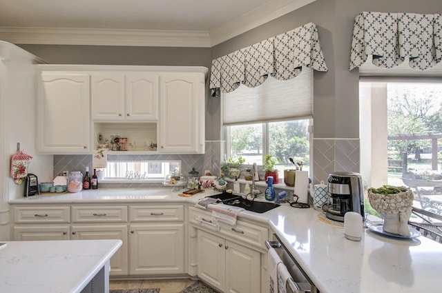 kitchen featuring tasteful backsplash, white cabinetry, and crown molding