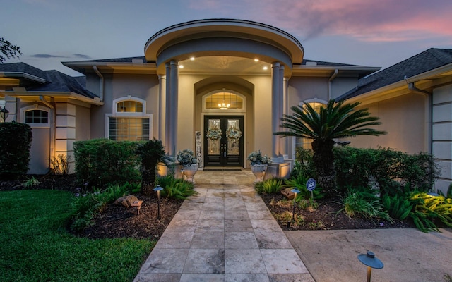 exterior entry at dusk featuring french doors