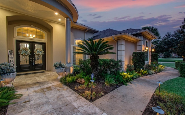 exterior entry at dusk featuring french doors