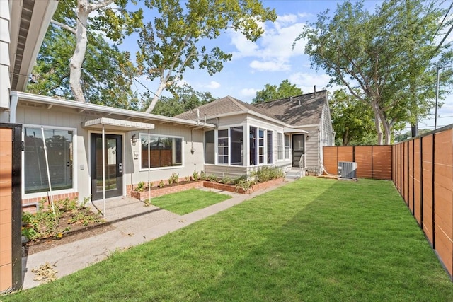 back of property featuring cooling unit and a lawn