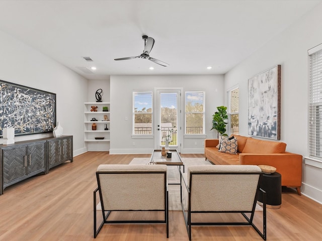 living room with ceiling fan and light hardwood / wood-style flooring