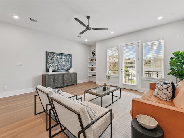 living room featuring ceiling fan and light wood-type flooring