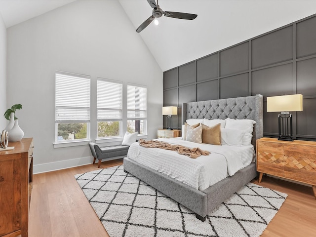 bedroom featuring ceiling fan, high vaulted ceiling, and light hardwood / wood-style flooring