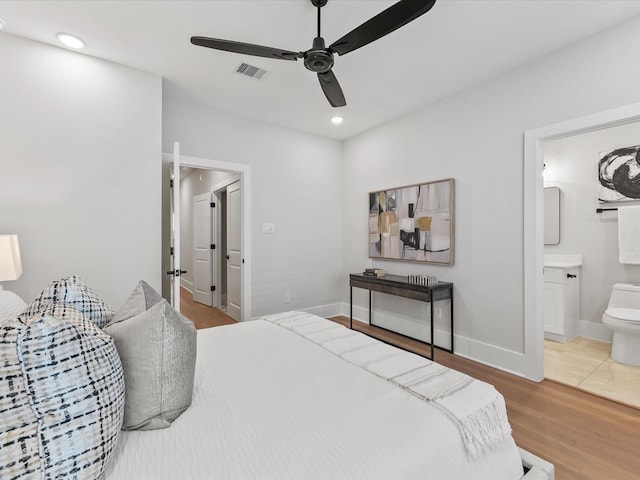 bedroom featuring hardwood / wood-style floors, ensuite bath, and ceiling fan