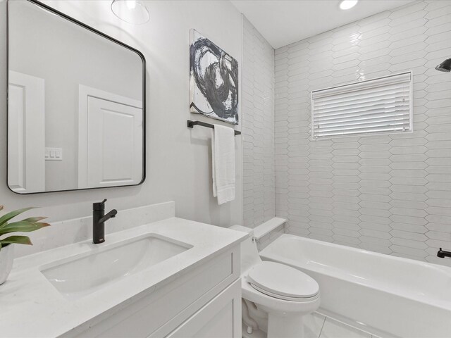 full bathroom featuring vanity, tiled shower / bath combo, and toilet