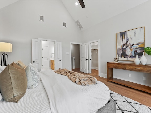 bedroom with hardwood / wood-style floors, a spacious closet, ceiling fan, ensuite bath, and a closet