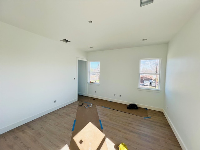 spare room featuring wood-type flooring and plenty of natural light