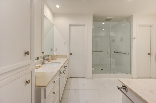 bathroom featuring a shower with door, vanity, and tile patterned flooring