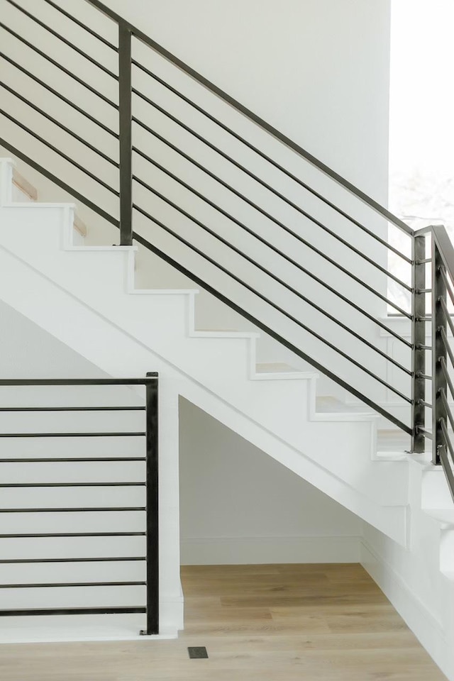 staircase featuring baseboards and wood finished floors