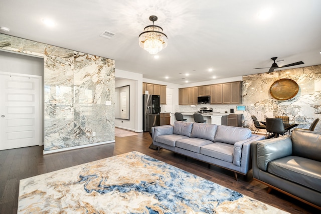 living room with ceiling fan with notable chandelier, dark wood-style floors, visible vents, and recessed lighting