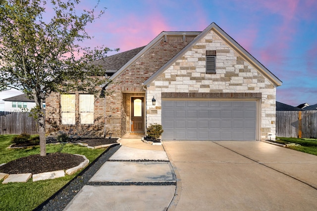 view of front of property with concrete driveway, brick siding, fence, and an attached garage