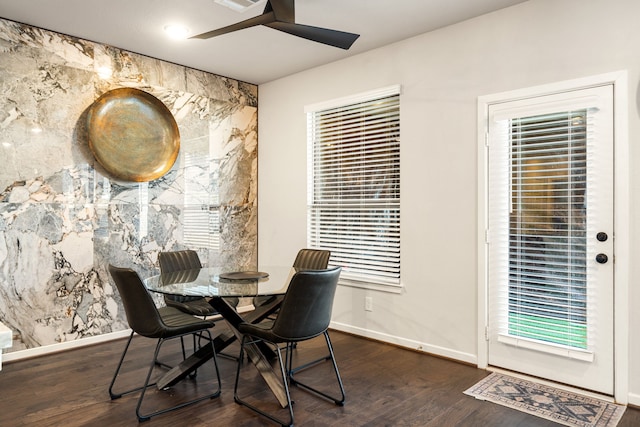 dining room featuring dark wood finished floors, baseboards, and ceiling fan