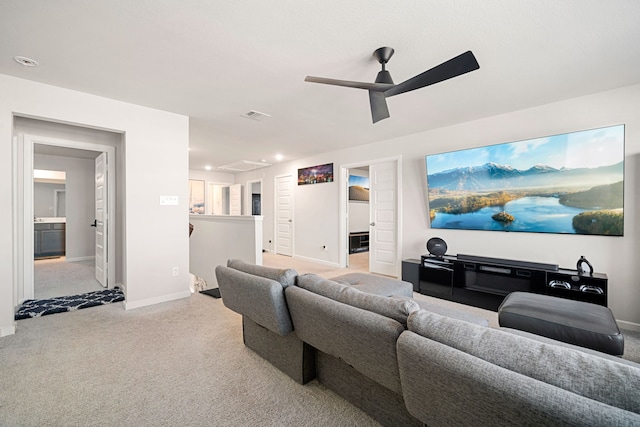 living area with baseboards, a ceiling fan, visible vents, and light colored carpet