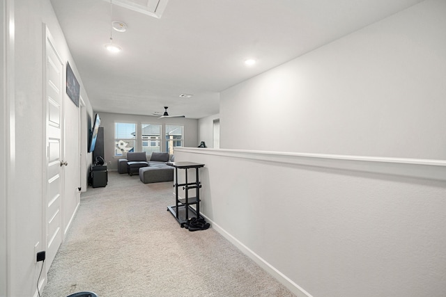 hallway featuring light carpet, attic access, baseboards, and recessed lighting