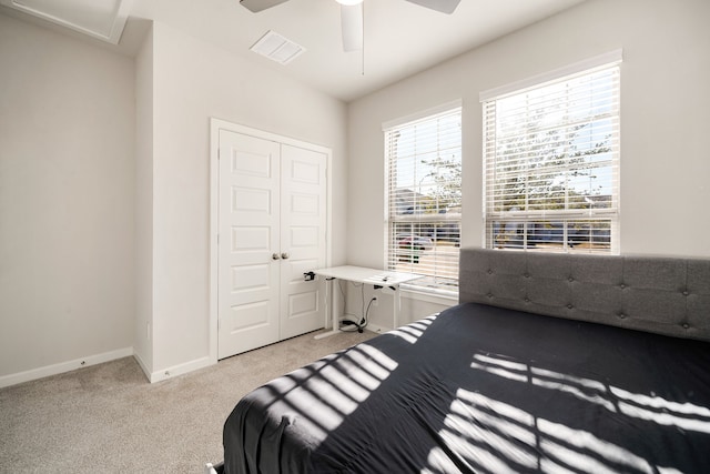 bedroom featuring light carpet, visible vents, baseboards, a ceiling fan, and a closet