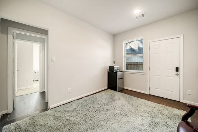 interior space featuring dark wood-type flooring, visible vents, and baseboards