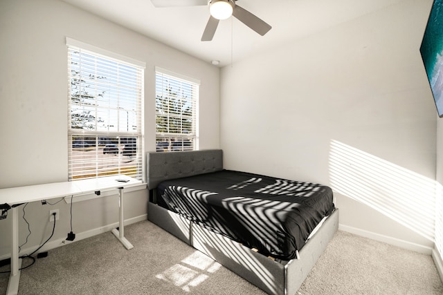 bedroom featuring a ceiling fan, light carpet, and baseboards