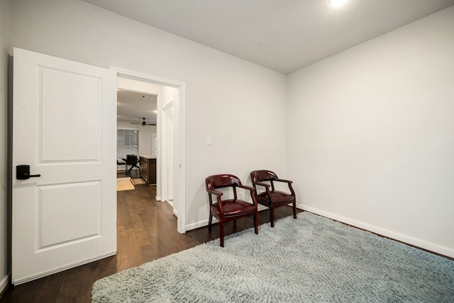 living area with dark wood-style flooring and baseboards