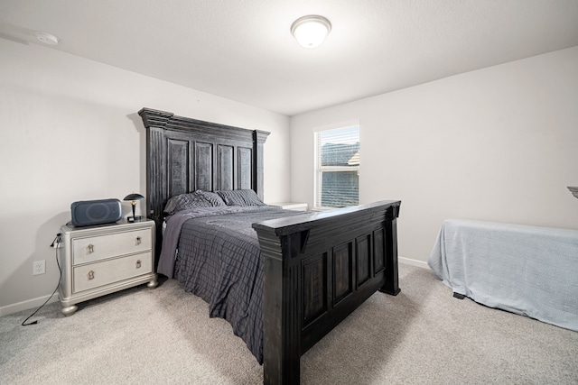 bedroom featuring light carpet and baseboards