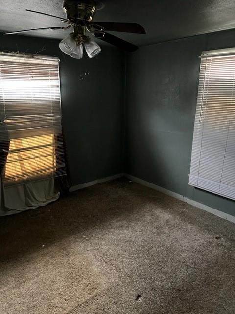 empty room with carpet flooring, a textured ceiling, and ceiling fan