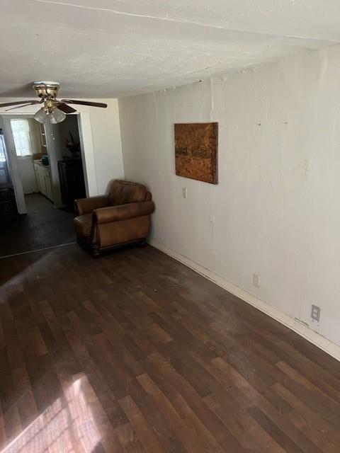 interior space featuring dark hardwood / wood-style flooring, ceiling fan, and a textured ceiling