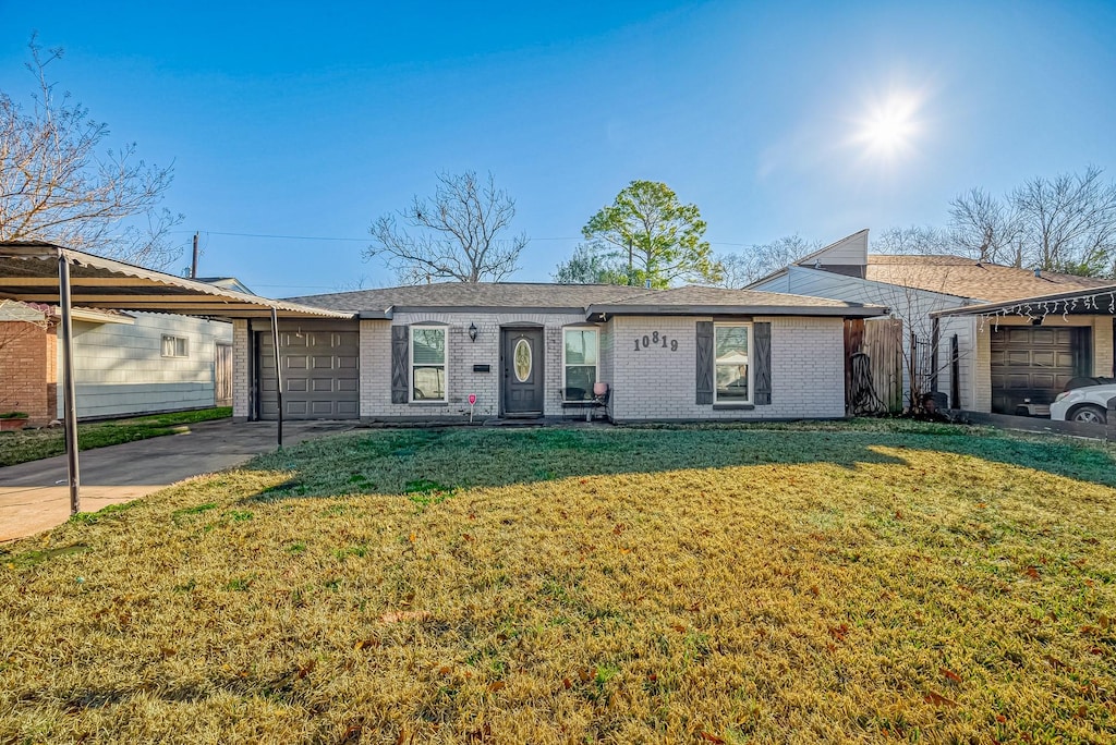 ranch-style home with a garage and a front lawn