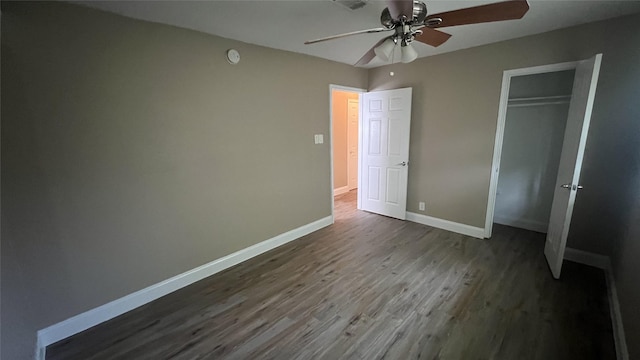 unfurnished bedroom with ceiling fan, dark hardwood / wood-style flooring, and a closet