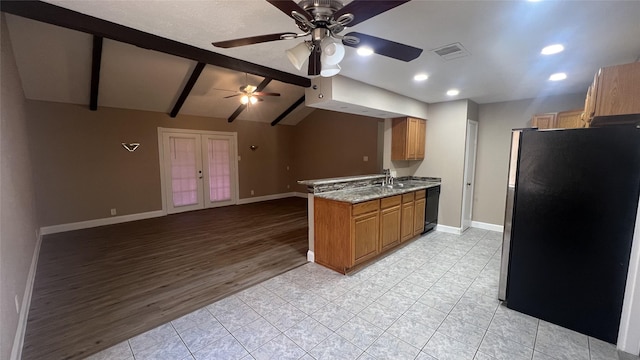 kitchen featuring sink, stainless steel fridge, light stone counters, lofted ceiling with beams, and french doors