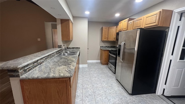 kitchen featuring sink, stainless steel appliances, kitchen peninsula, light tile patterned flooring, and dark stone counters