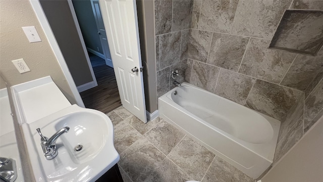 bathroom with tiled shower / bath combo and sink