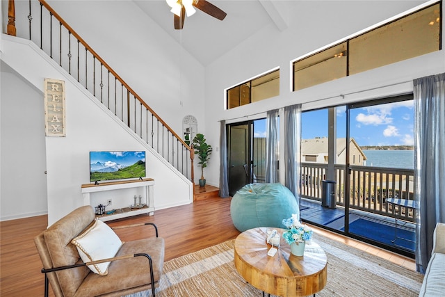 living room with hardwood / wood-style flooring, ceiling fan, high vaulted ceiling, and beamed ceiling