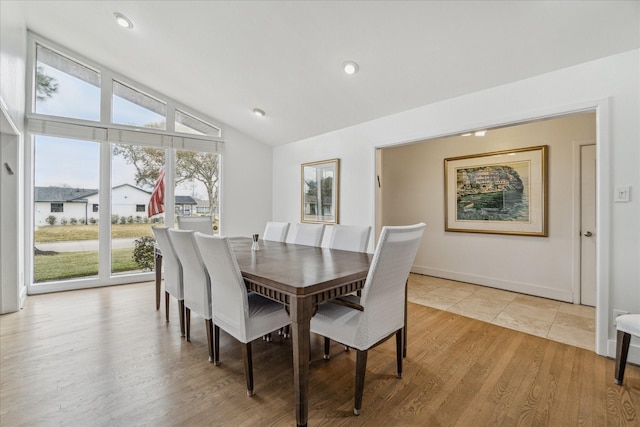 dining room featuring vaulted ceiling and light wood-type flooring