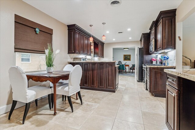 kitchen featuring pendant lighting, light stone countertops, and tasteful backsplash