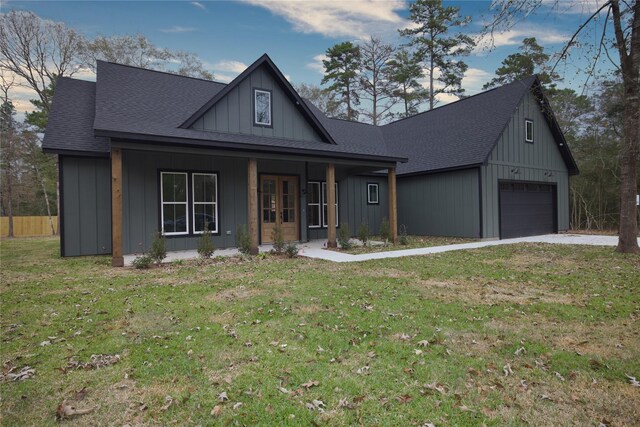 view of front facade with a garage, a front lawn, and covered porch