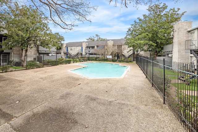 view of swimming pool featuring central AC unit and a patio