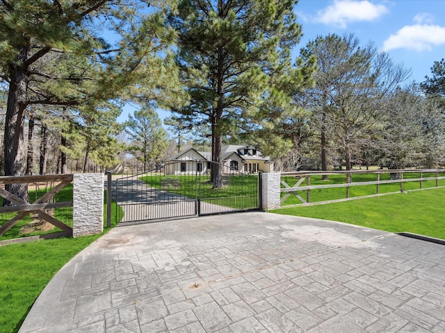 view of gate with a lawn and fence